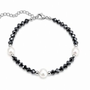 A bracelet featuring small black beads and small white pearls, with a clasp and an adjustable extender chain.