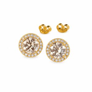 A pair of gold stud earrings featuring a large round colored stone surrounded by a halo of smaller clear stones, with butterfly backs.