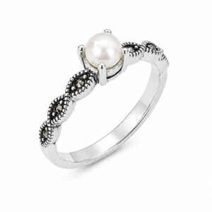 Angled view of a silver marcasite ring with a white freshwater pearl and leaf-detail shoulders