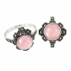 Two silver rings featuring a round pink stone and small dark stones.