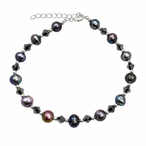 A bracelet featuring alternating dark pearls and dark beads, with a clasp and an adjustable extender chain.