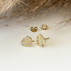 A pair of gold stud earrings shaped like delicate, textured tropical palm leaves.